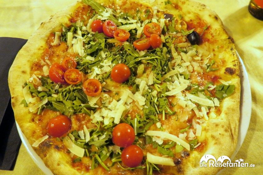 Eine Pizza mit Ruccola und Cherrytomaten bei der Grotta Marcello in Cagliari auf Sardinien