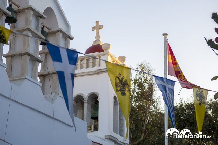 Fahnen und ein Kirchturm in Mykonos Stadt