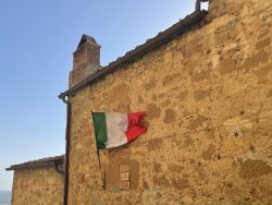 Häuserfassade mit italienischer Flagge in Pienza